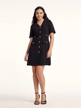 a curvy lady in black a-line dress with black strap sandals